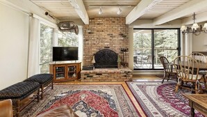 Una sala de estar acogedora con chimenea, asientos cómodos y ventanas amplias.