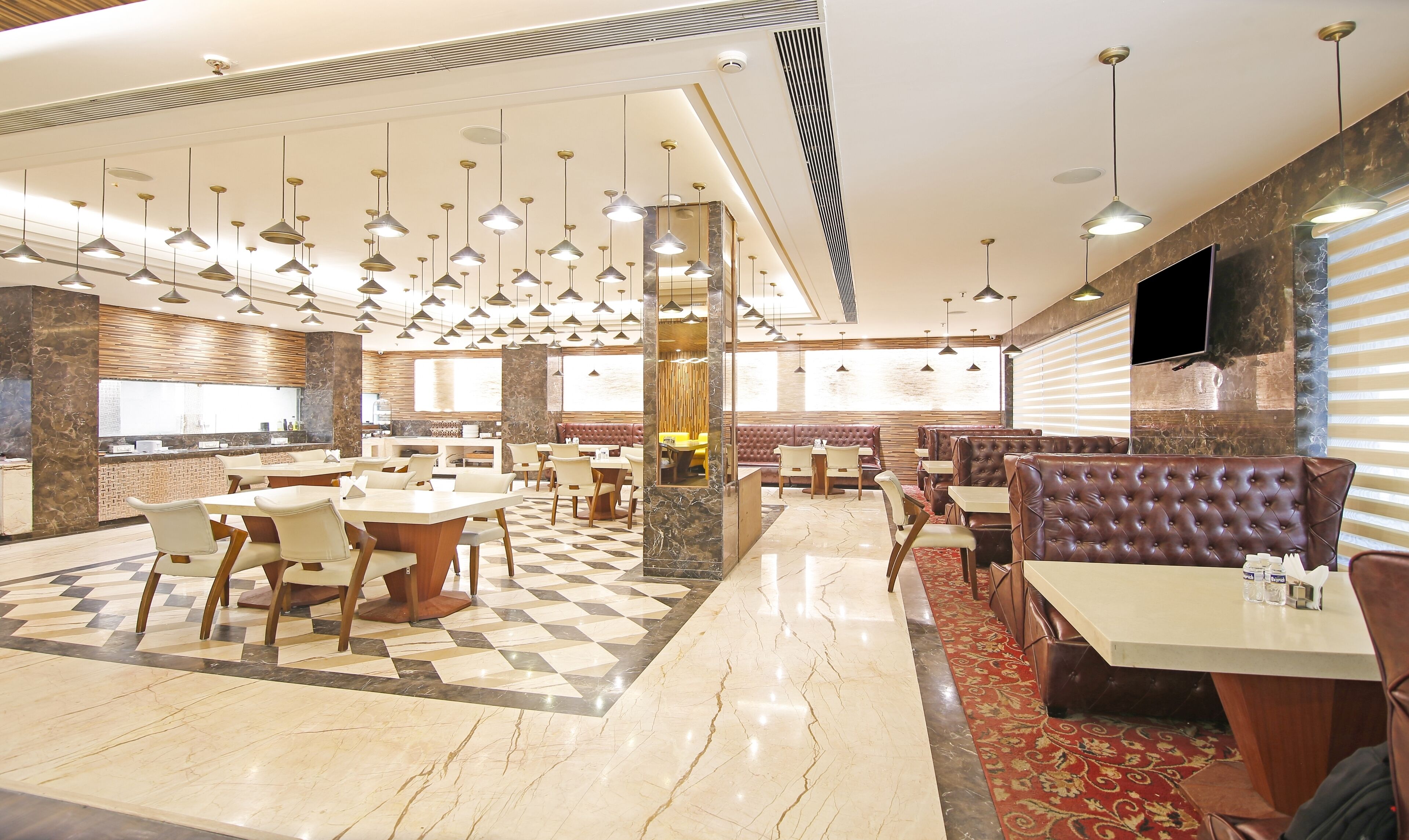 A modern restaurant with multiple dining areas, including booths and tables, and a checkered floor pattern.