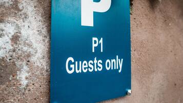 Señal azul de estacionamiento con una 'P' blanca y 'P1', indicando zona de estacionamiento para huéspedes.