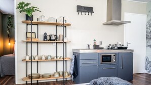A modern kitchen with built-in appliances, wooden shelves, and a grey cabinet. - The Lion King (Groningen)
