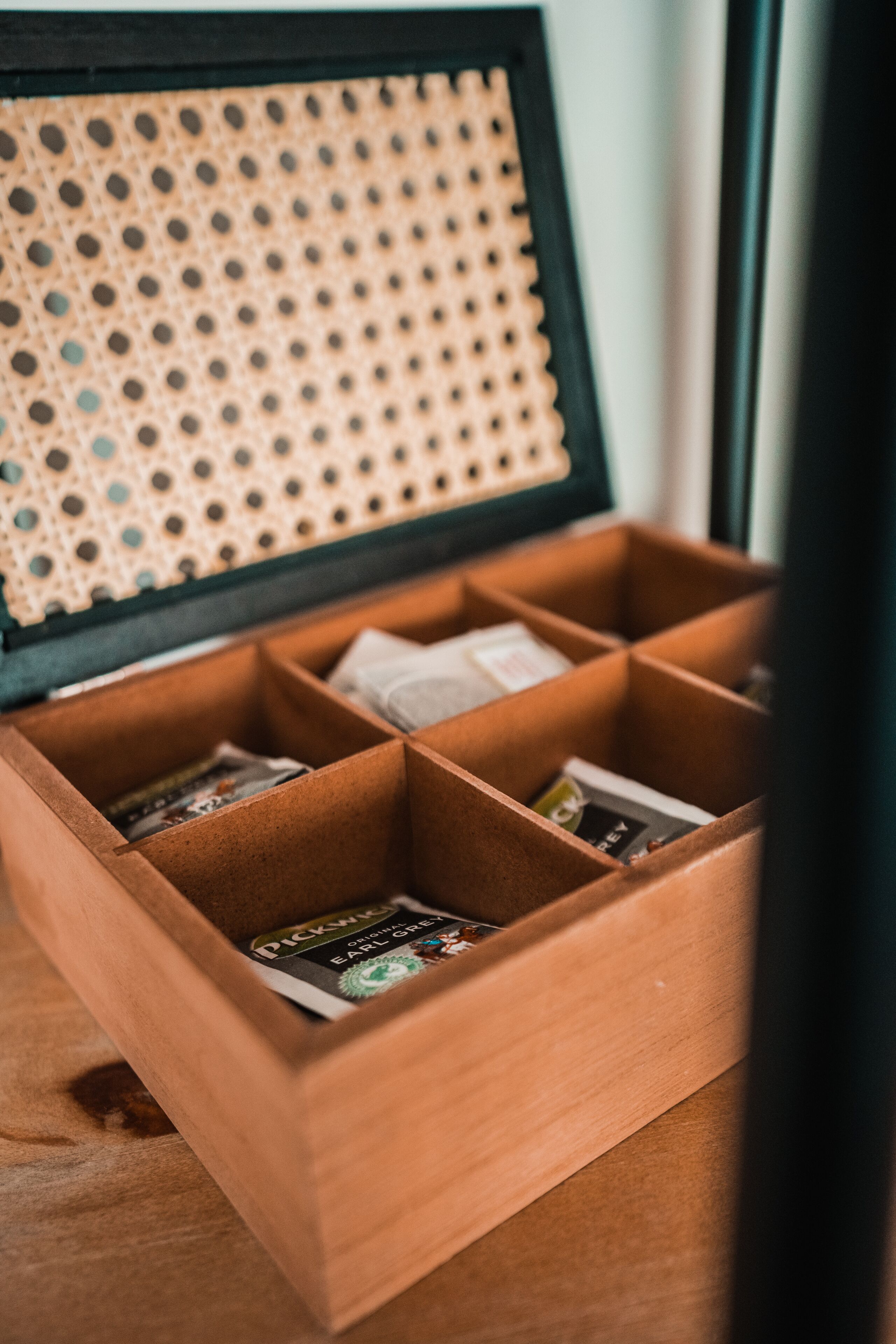 Una caja de madera con varios compartimentos, algunos con libros.