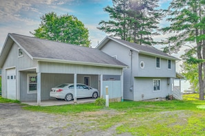 Ein zweistöckiges Haus mit Garage und überdachter Veranda.