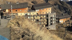 A mountain lodge with multiple wooden buildings, a ski lift, and a snow-capped mountain in the background. - Lovely T3 duplex Orcières Merlette resort (Orcières)