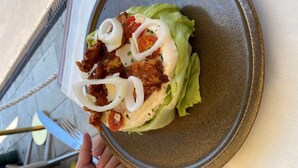 Un plato con un sándwich sobre una bandeja de cerámica.
