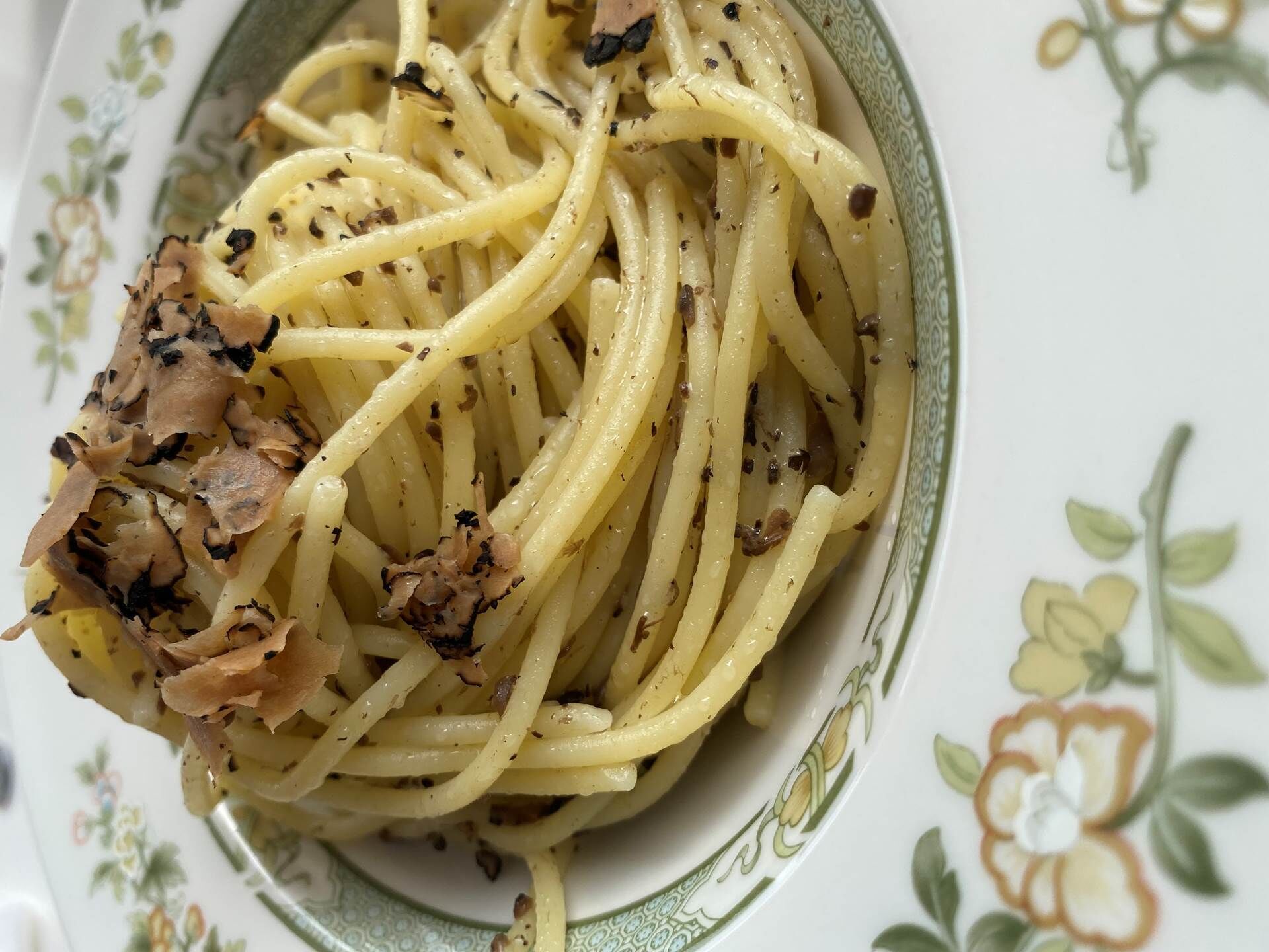 A plate of spaghetti with a creamy sauce and black pepper.
