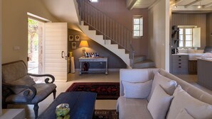 A spacious living room with a staircase, a dining area, and a kitchen. - Liodentra (West Mani)