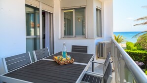 A balcony with a table set for two, a bottle, and a tray of fruit. - Beachfront Apartment - Peace and Beach - UHC RIVIERA (Miami Playa)