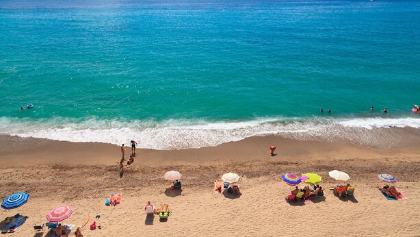 A beach with people sunbathing and swimming, and several colorful umbrellas. - Beachfront Apartment - Peace and Beach - UHC RIVIERA (Miami Playa)