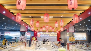 A restaurant interior with red lanterns, a buffet area, and a large screen displaying a scenic image. - Binh An Nhien Hotel (Hoa Lu)