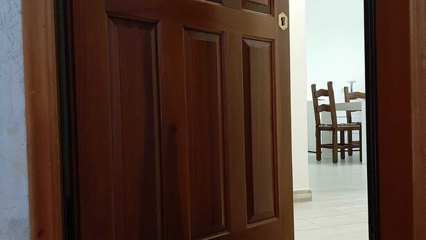 Una puerta de madera con un ojo de cerradura y un felpudo que dice 'WELCOME'.