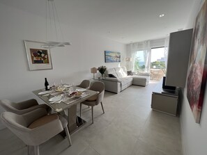 Un salon moderne comprenant un coin repas, un canapé et un téléviseur.