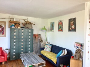 Un salon chaleureux avec un canapé bleu, une table basse en bois et un meuble vert.