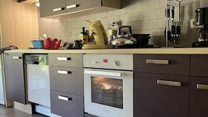 Ett modernt kök med mörka skåp, en inbyggd ugn och en diskmaskin.