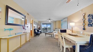 Habitación de hotel con comedor, ventana grande y ventilador de techo.