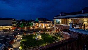 A residential area with houses, a well-lit street, and a small park with a statue. - Manigram Bishram Batika Pvt Ltd (Tilottama)
