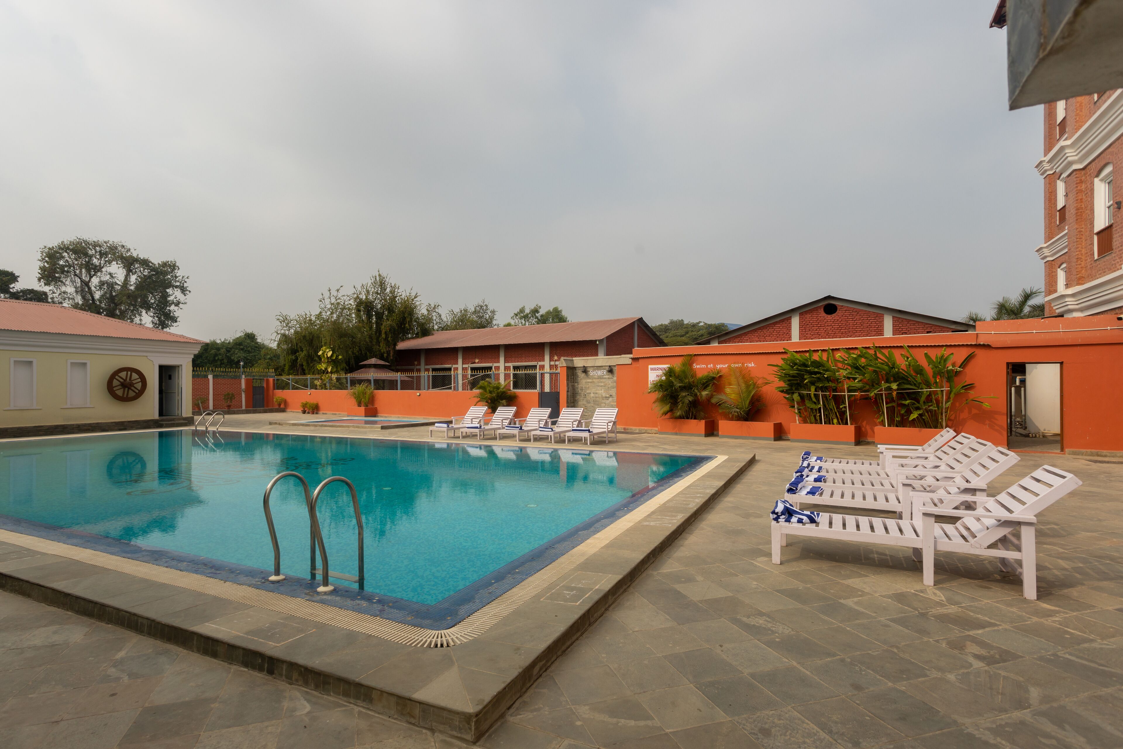 A swimming pool with lounge chairs and a stone-tiled deck.
