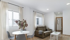 Ein modernes Wohnzimmer mit einem Esstisch, grauen Stühlen, einer Couch und einem Couchtisch.