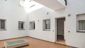 Ein großzügiger Innenbereich mit einem großen rechteckigen Pool, mehreren Fenstern und einer Tür zu einem anderen Raum.
