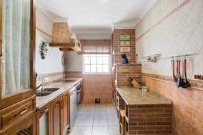 A kitchen with wooden cabinets, a brick backsplash, and a window.