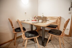 Un coin repas avec une table en bois, quatre chaises et un panier.