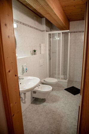 A bathroom with a sink, toilet, and shower.