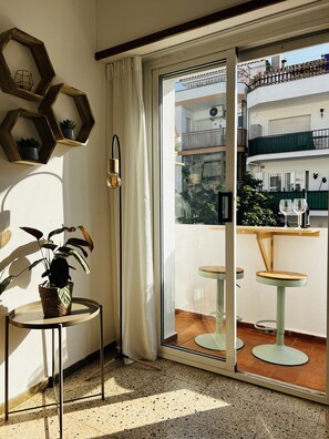 A room with a sliding glass door leading to an outdoor balcony with two round tables and chairs. - Charming apartment in Tossa de Mar (Tossa de Mar)