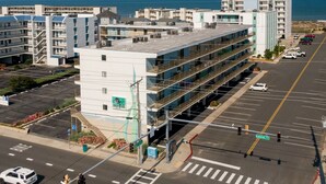 Un aparcamiento de varios pisos con pasillo cubierto, junto a una zona costera con edificios y vista al mar.
