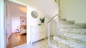Eine Treppe mit Marmorstufen, die zu einer Zwischenebene führt.