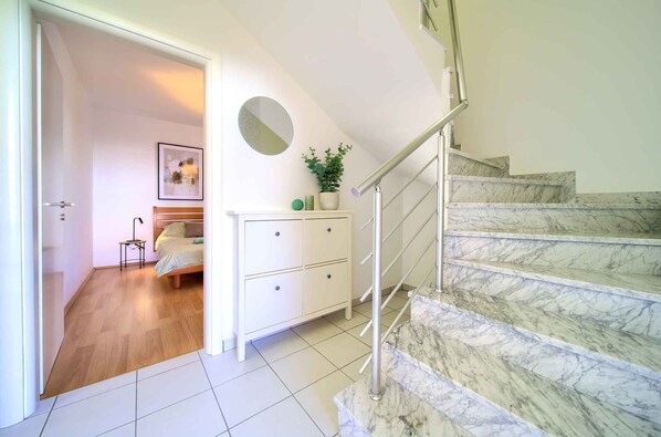 A staircase with marble steps leading to a landing.