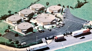 Vista aérea de una zona residencial con varias casas, una carretera y un hotel.