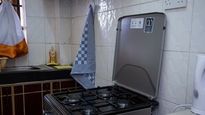 A kitchen with a gas stove, a sink, and a countertop. - Letai Homes Furnished Apartment (Nairobi)