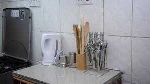 A kitchen counter with a coffee maker, salt and pepper shakers, wooden spoons, and a utensil holder. - Letai Homes Furnished Apartment (Nairobi)