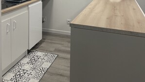 A kitchen with white cabinets, a microwave, a coffee maker, and a wooden countertop. - Apartment in the center of Castelnaudary (Castelnaudary)