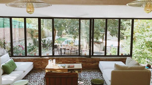 A cozy living room with a large window, a sofa, a coffee table, and a patterned floor. - Provencal villa 15 minutes from Cassis and the calanques (Gémenos)