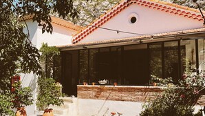 A house with a red-tiled roof, a glass front, and a brick patio. - Provencal villa 15 minutes from Cassis and the calanques (Gémenos)