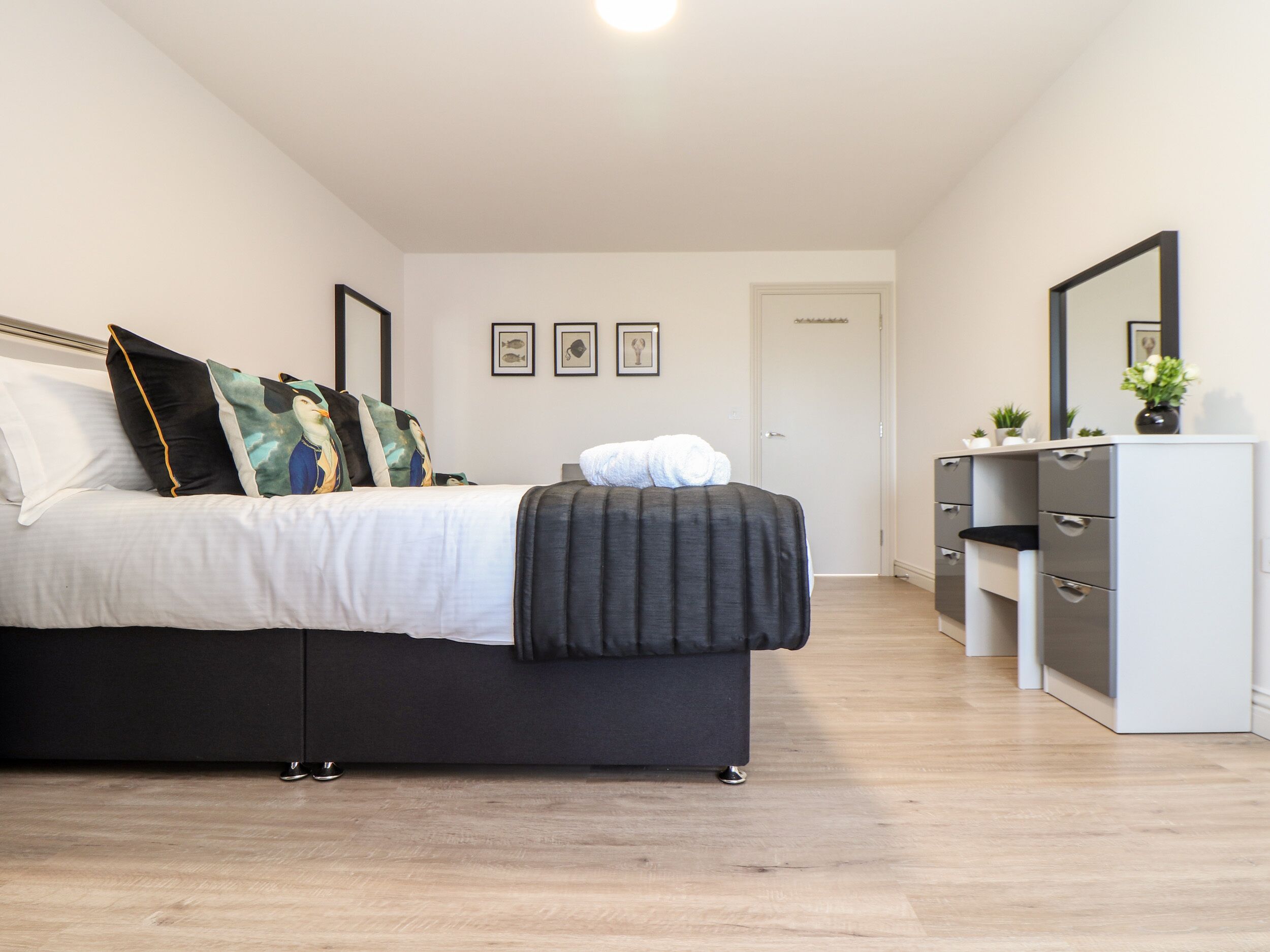 Una camera da letto moderna con un letto, comodini, una cassettiera e uno specchio.