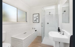 Enjoy a relaxing soak in the bathtub or refreshing shower, with a separate sink area for added convenience.