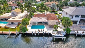 A residential area with a swimming pool, a boat dock, and palm trees. - 943 Managed by Brampton Park (Delray Beach)