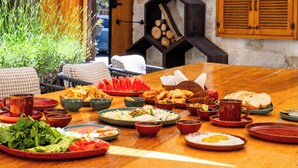 A dining table with various dishes, a wicker chair, and a wooden cabinet. - Sedirli Konak 1751 - Special Class (Ürgüp)