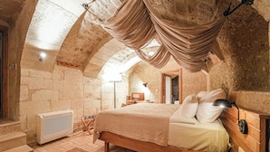 A bedroom with a vaulted ceiling, a bed, a radiator, and a wooden floor. - Sedirli Konak 1751 - Special Class (Ürgüp)