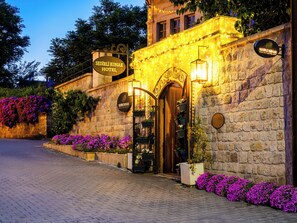 Un edificio in pietra con un cartello che indica 'Sedirli Konak Hotel' e un ingresso in legno.
