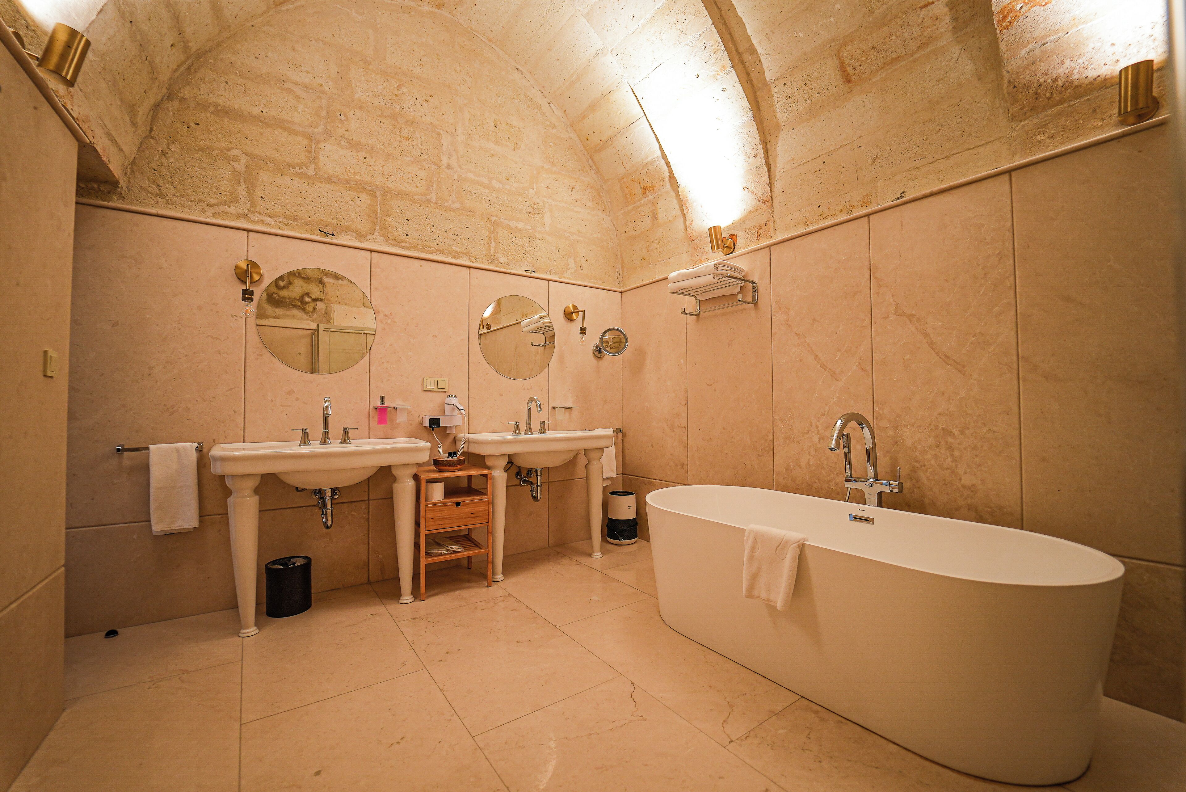 A bathroom with a freestanding bathtub, two sinks, and a vanity with a mirror.