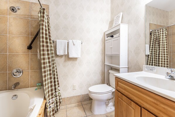 A bathroom with a bathtub, toilet, and sink.