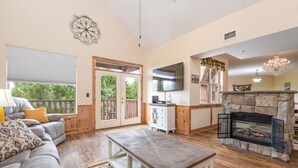 A spacious living room with a fireplace, a sofa, a coffee table, and a television.