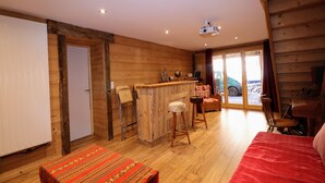 A cozy cabin interior with a wooden interior, a bar area, and a view of the outside.