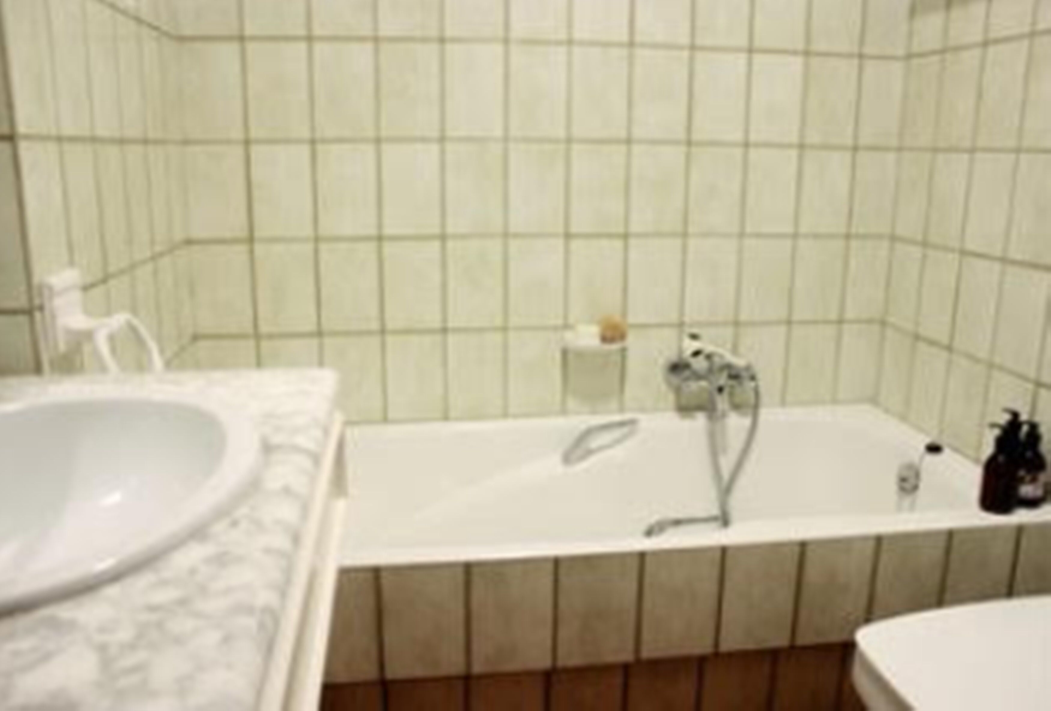 A bathroom with a white bathtub, a white sink, and a white toilet.