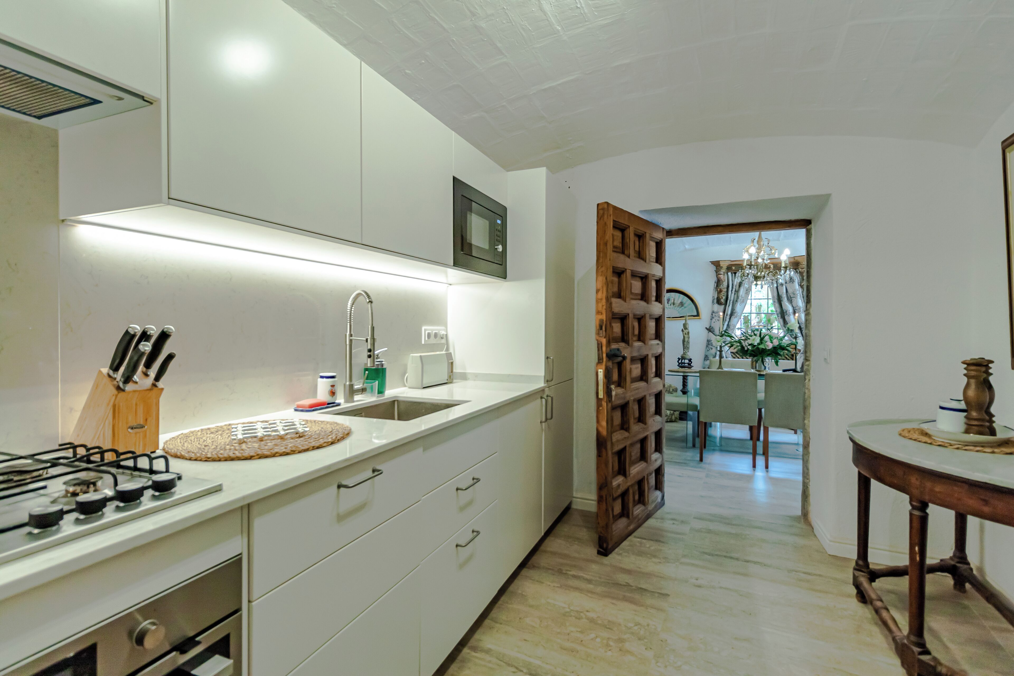 A modern kitchen with white cabinets, a gas stove, and a built-in microwave.