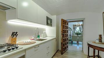 A modern kitchen with white cabinets, a gas stove, and a built-in microwave.