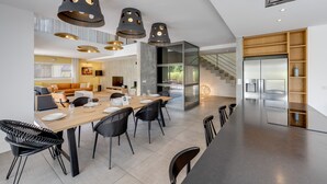 Una cocina moderna con una isla grande, electrodomésticos integrados y una escalera que lleva a un nivel superior.