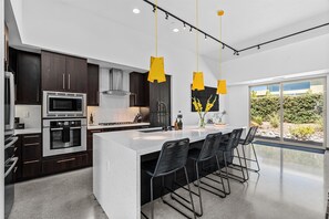 Stainless steel appliances in kitchen with large island.